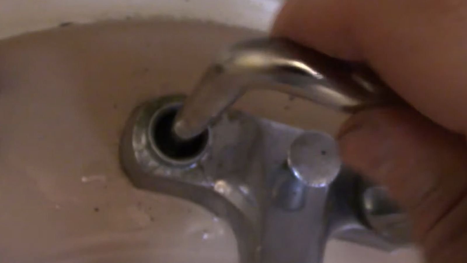 Technician repairing a kitchen faucet in a Naples, FL home